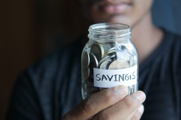 Man holding a jar of coins