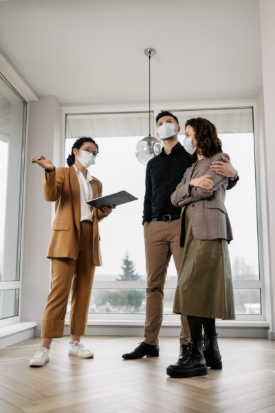 Image of a real estate agent showing two people a home