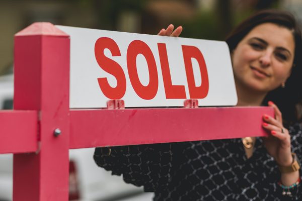 a realtor placing a sold sign.