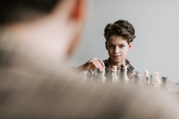 Kid playing chess planning something