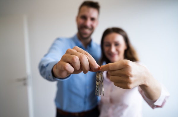 A happy couple holding up the keys to their new home